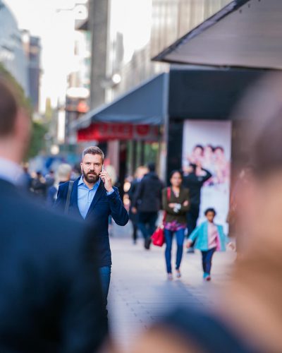 hipster-manager-with-smart-phone-walking-in-the-PFKTPR9(1)